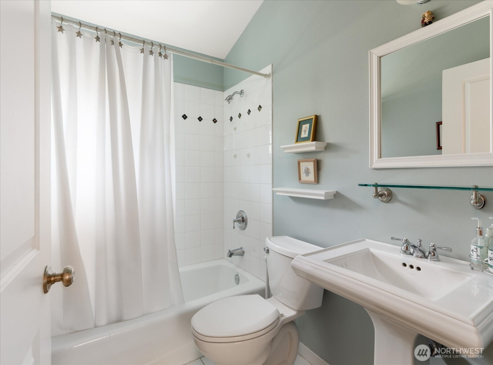 8210 Nob Road Clinton, WA 98236 - Photo 23 of 40 a bathroom with a sink a toilet and shower curtain