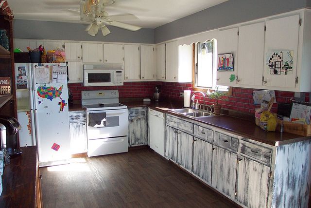 320 Kay Street Manhattan, IL 60442 - Photo 9 of 27 a kitchen with stainless steel appliances kitchen island granite countertop a stove a sink dishwasher and white cabinets with wooden floor