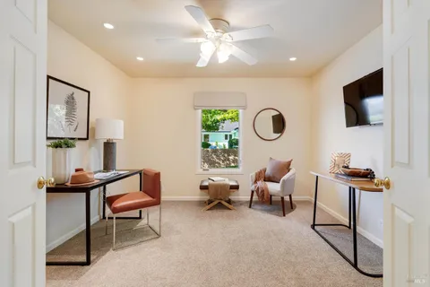 a living room with furniture a flat screen tv and a window