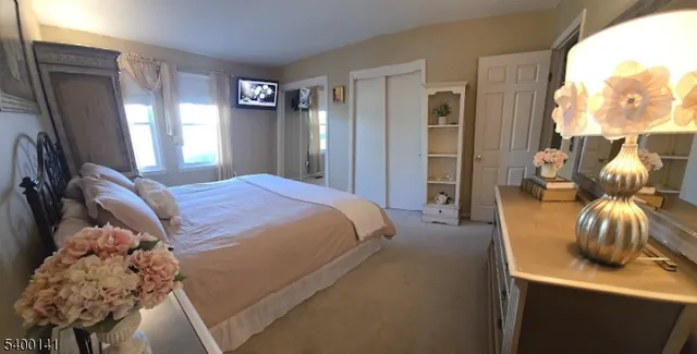 a bedroom with a bed and dresser with mirror