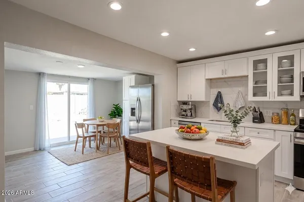 a kitchen with a dining table chairs and wooden floor