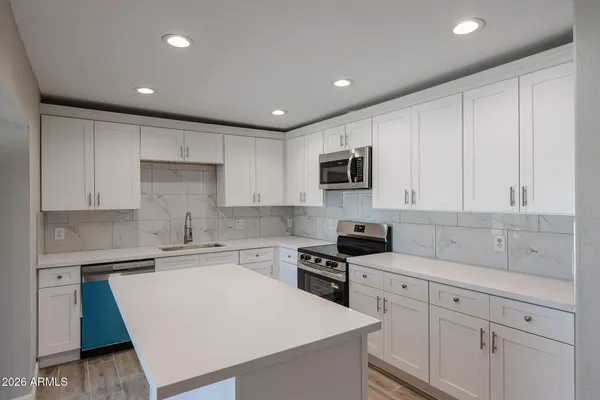 a kitchen with white cabinets and stainless steel appliances