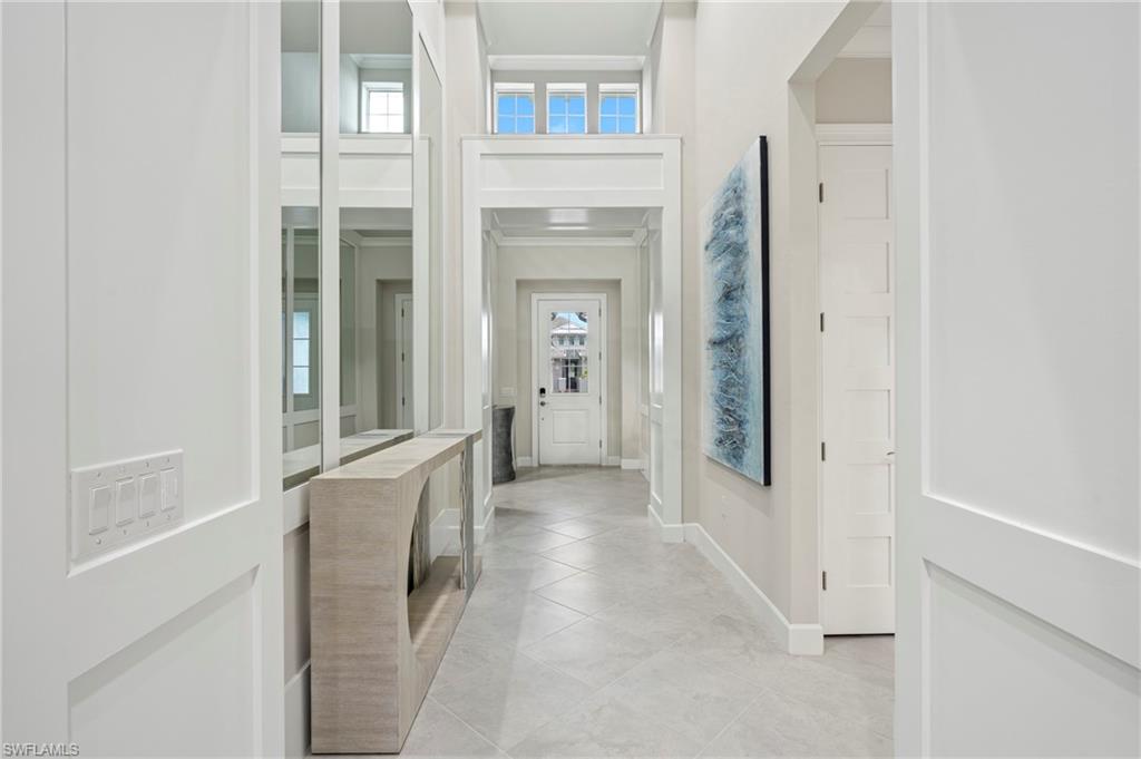 8795 Calypso Court Naples, FL 34113 - Photo 6 of 49 a view of a hallway with wooden shelves