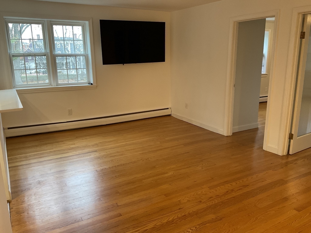 26 Summer Street, Unit 8 Marblehead, MA 01945 - Photo 11 of 23 a view of an empty room with wooden floor and a window