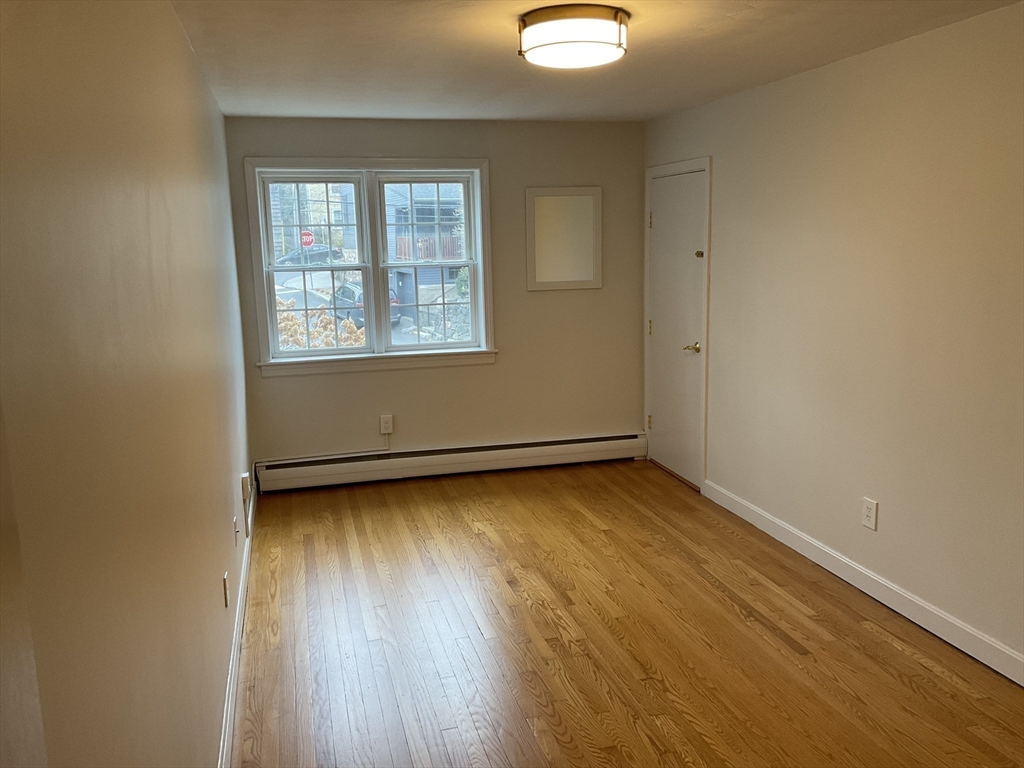 26 Summer Street, Unit 8 Marblehead, MA 01945 - Photo 13 of 23 an empty room with wooden floor and windows