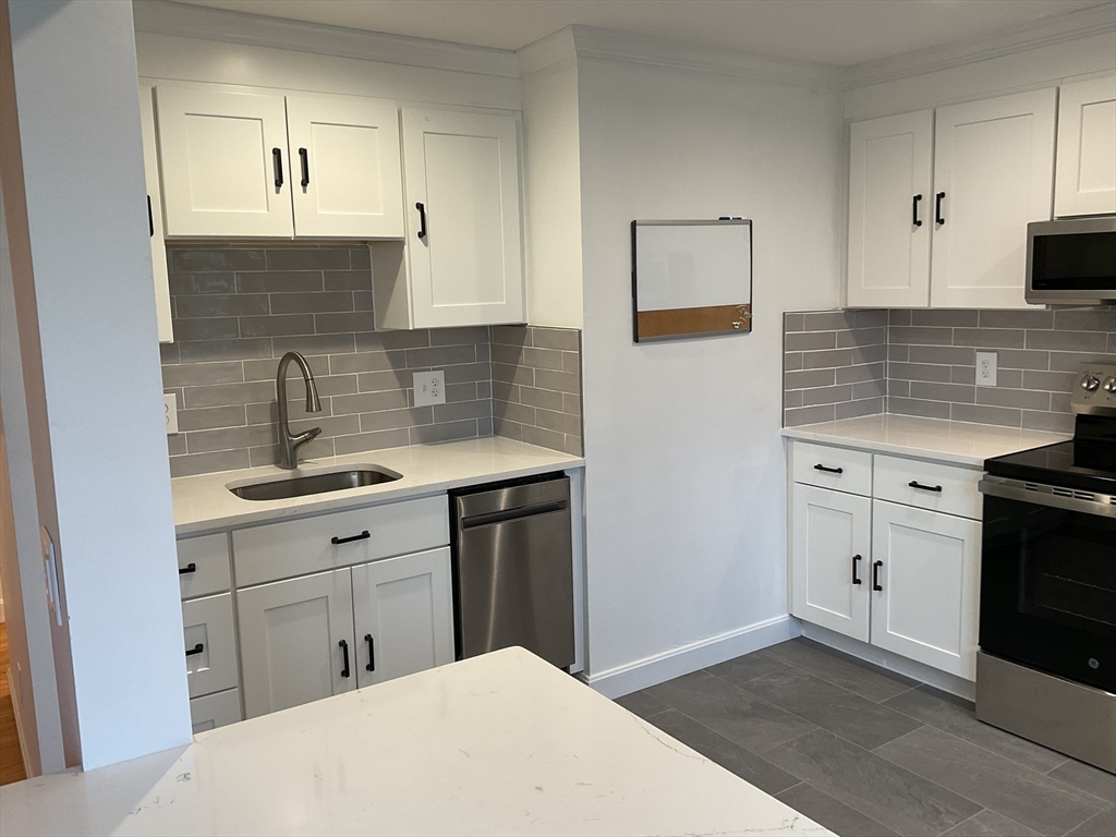 26 Summer Street, Unit 8 Marblehead, MA 01945 - Photo 4 of 23 a kitchen with a sink stove and cabinets