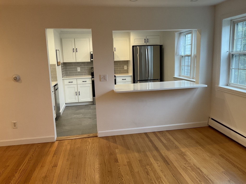 26 Summer Street, Unit 8 Marblehead, MA 01945 - Photo 8 of 23 an empty room with wooden floor and windows