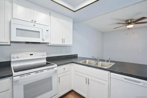 a kitchen with white cabinets appliances and a sink