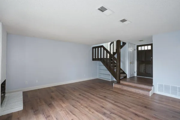 a view of a hallway with wooden floor and staircase