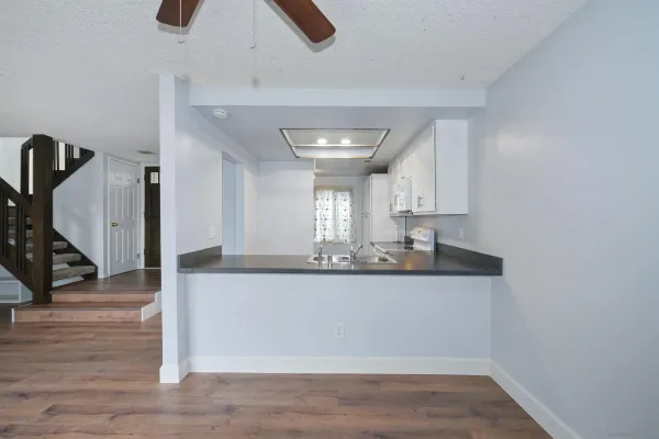 a view of a kitchen with wooden floor and electronic appliances