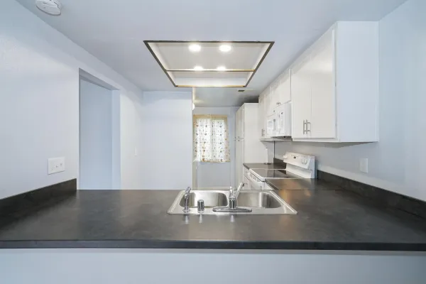 a kitchen with a sink a counter space and a window