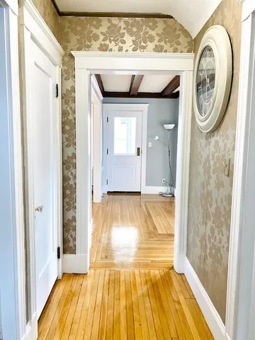 a view of entrance to door with wooden floor