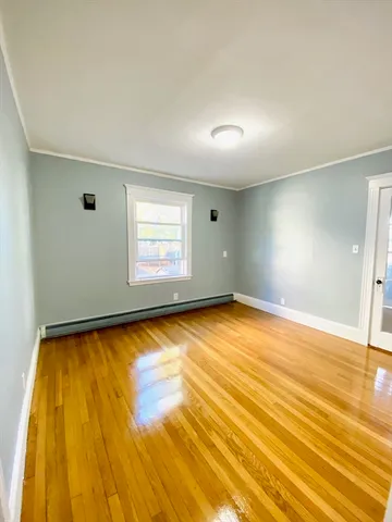 a view of empty room with window and wooden floor