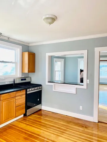 a view of a kitchen with wooden floor and a sink