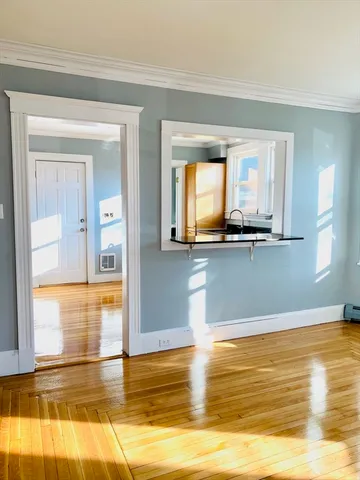 a view of a room with wooden floor and a window