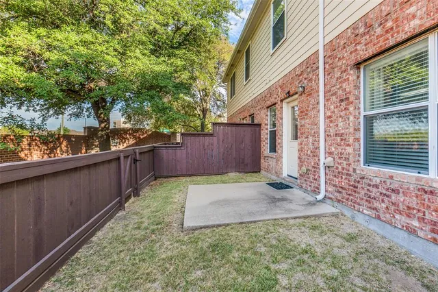 a view of backyard with wooden fence and large trees