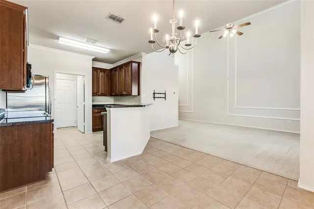 a kitchen with granite countertop a refrigerator and a stove top oven
