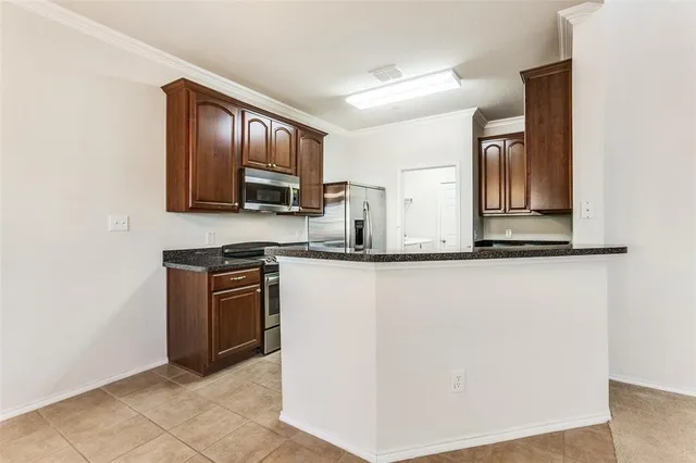 a kitchen with granite countertop cabinets and black stainless steel appliances