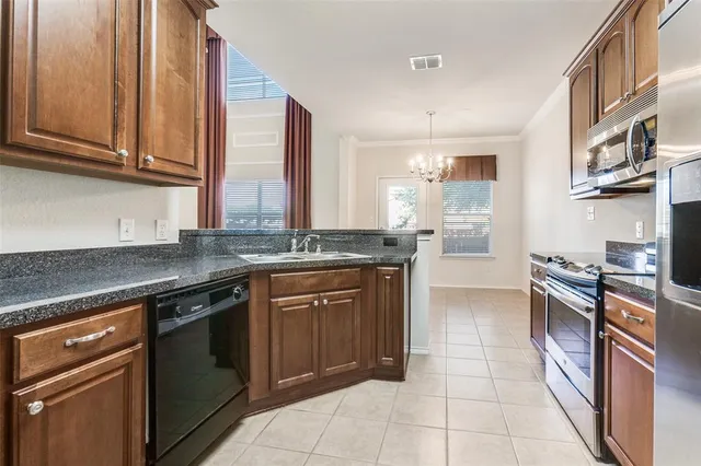 a kitchen with stainless steel appliances granite countertop a stove a sink and a microwave