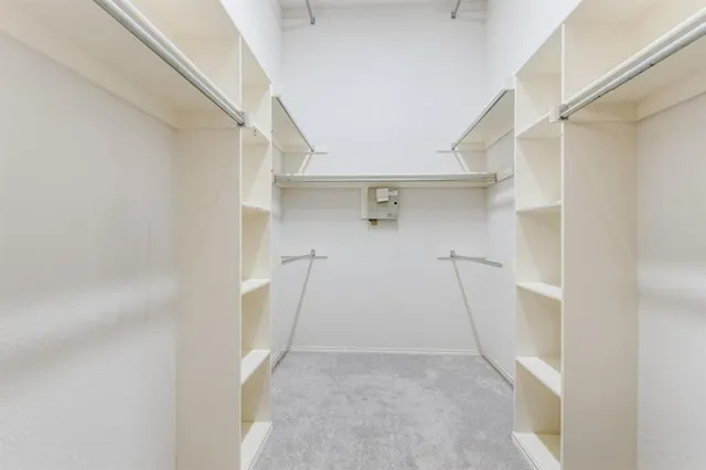a view of walk in closet with empty racks