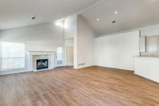 a view of an empty room with a fireplace and a window