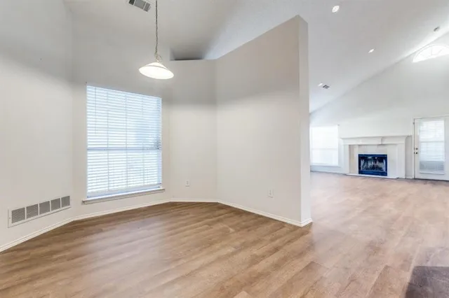 a view of an empty room with a window and fireplace
