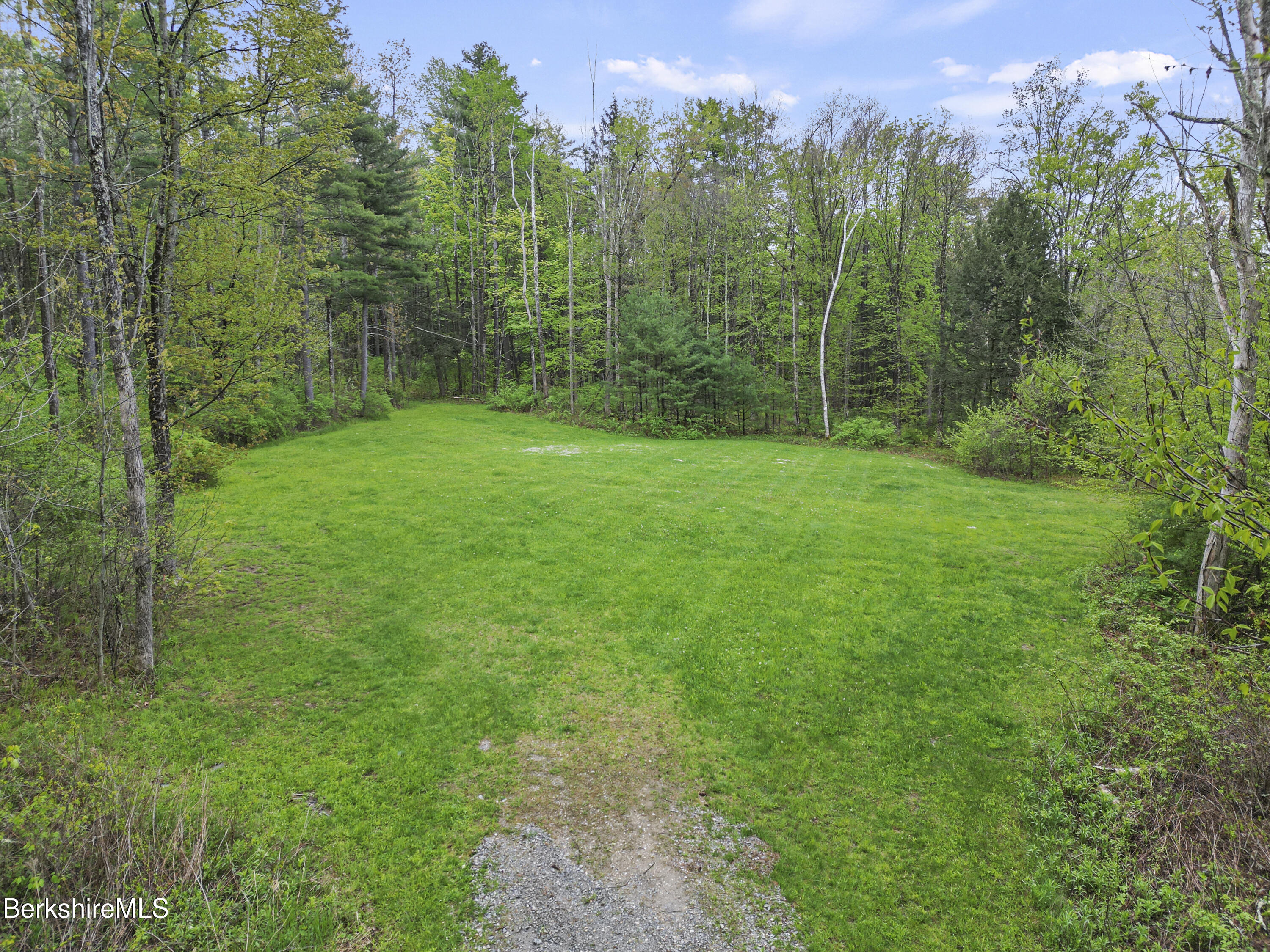 286 Lee Road Lenox, MA 01240 - Photo 14 of 26 a view of a lush green forest with trees and a building