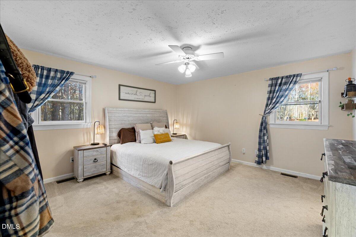 850 Lewis Winstead Loop Roxboro, NC 27574 - Photo 18 of 49 a spacious bedroom with a bed and a couch