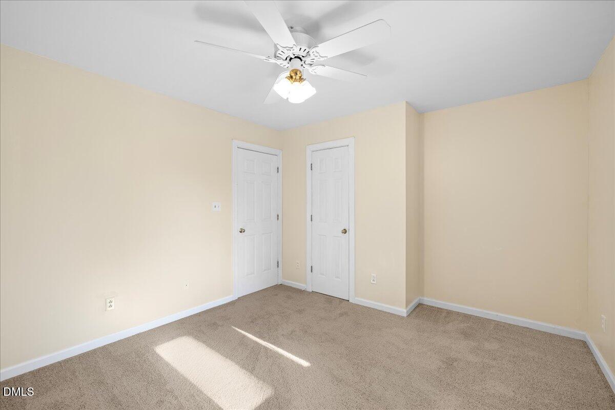 850 Lewis Winstead Loop Roxboro, NC 27574 - Photo 25 of 49 an empty room with windows and fan
