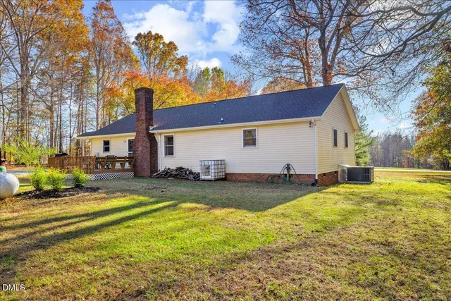 a view of a house with backyard and trees