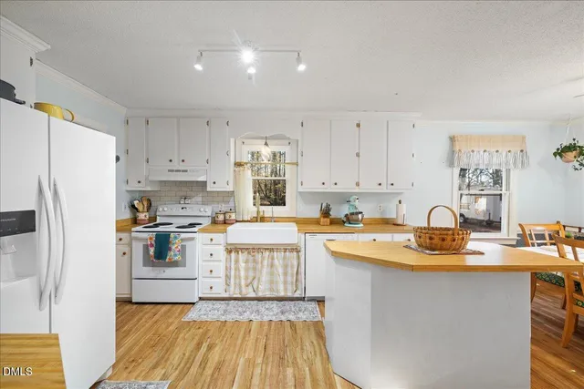 a kitchen with stainless steel appliances granite countertop a stove a sink dishwasher and a refrigerator
