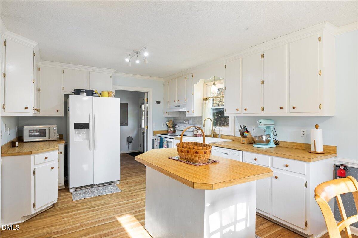 850 Lewis Winstead Loop Roxboro, NC 27574 - Photo 8 of 49 a kitchen with stainless steel appliances a refrigerator a sink a stove a table and chairs