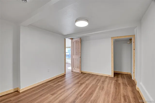 a view of an empty room and wooden floor