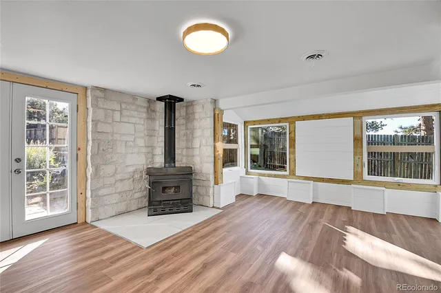 a view of a fireplace with wooden floor and windows