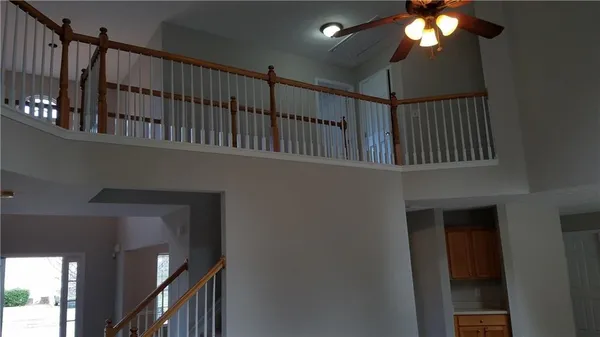a view of staircase with railing and a chandelier
