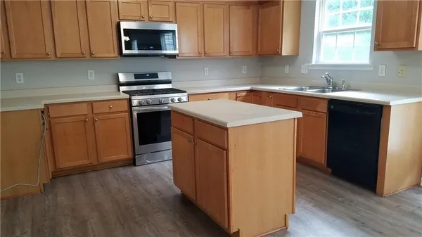 a kitchen with stainless steel appliances granite countertop a sink stove and microwave