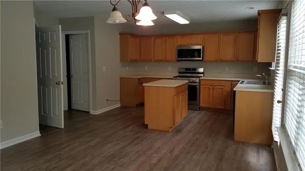 a kitchen with granite countertop wooden floors and stainless steel appliances