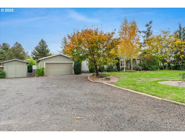 a front view of a house with a yard and trees