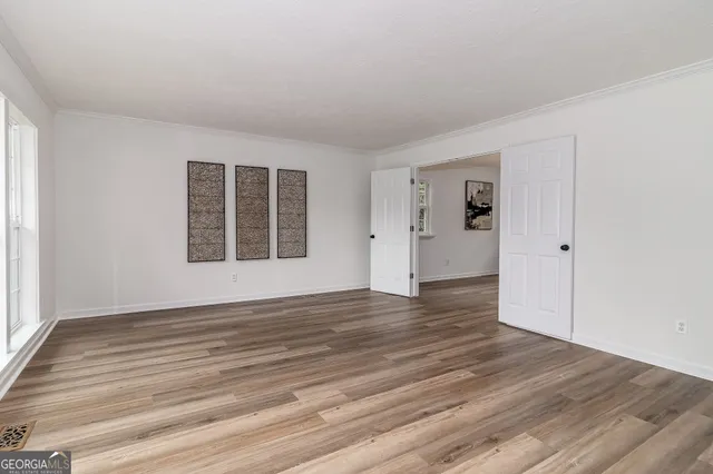 a kitchen with stainless steel appliances granite countertop a refrigerator a sink dishwasher a stove and white cabinets with wooden floor