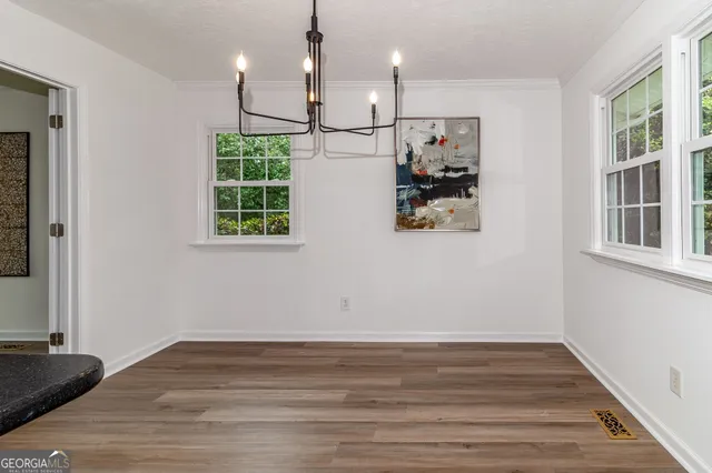 an empty room with wooden floor and ceiling fan
