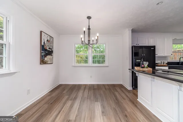 an empty room with wooden floor and ceiling fan