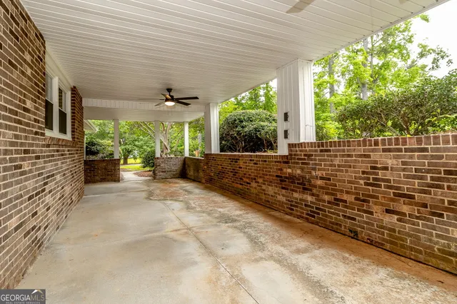 an aerial view of residential house with outdoor space and trees all around