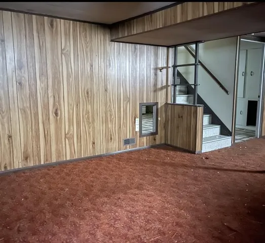 a front view of a house with a yard and a tree