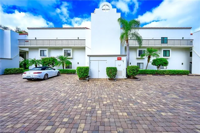 a front view of a house with a yard and potted plants