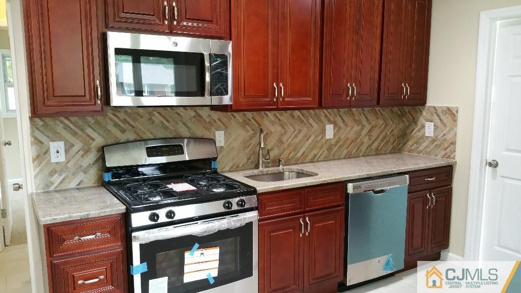125 Winthrop Road Edison, NJ 08817 - Photo 16 of 23 a kitchen with granite countertop cabinets stove top oven and microwave