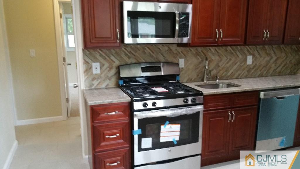 125 Winthrop Road Edison, NJ 08817 - Photo 17 of 23 a kitchen with a stove and a microwave