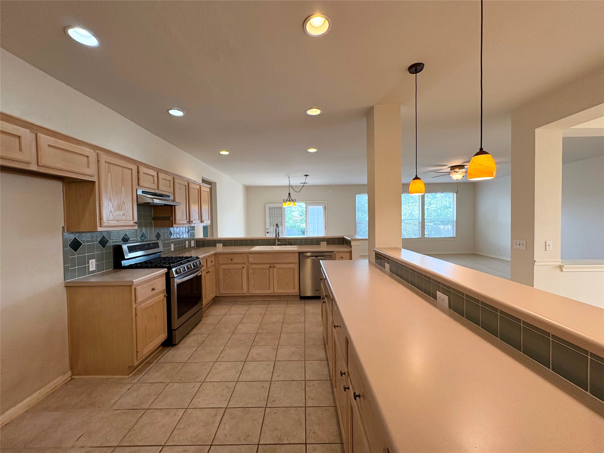 7006 Rambollet Terrace Round Rock, TX 78681 - Photo 15 of 38 An open concept kitchen features stainless steel appliances and abundant counter space, flowing into the living area.