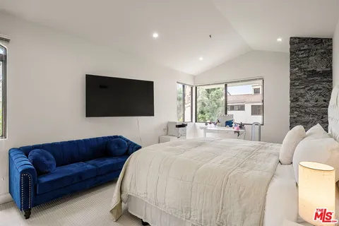a living room with a couch a flat screen tv and a large window