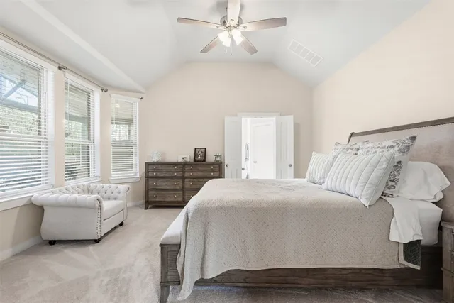 a spacious bedroom with a bed and a chandelier