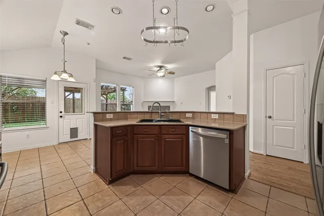 a kitchen with stainless steel appliances granite countertop a stove a sink and a refrigerator